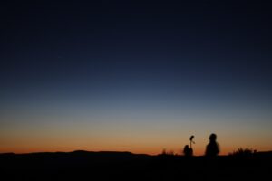 people standing on top of a hill at night